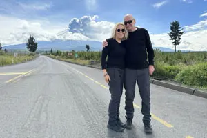 Couple in Cotopaxi National Park witnessing the majestic Cotopaxi volcano erupting ash